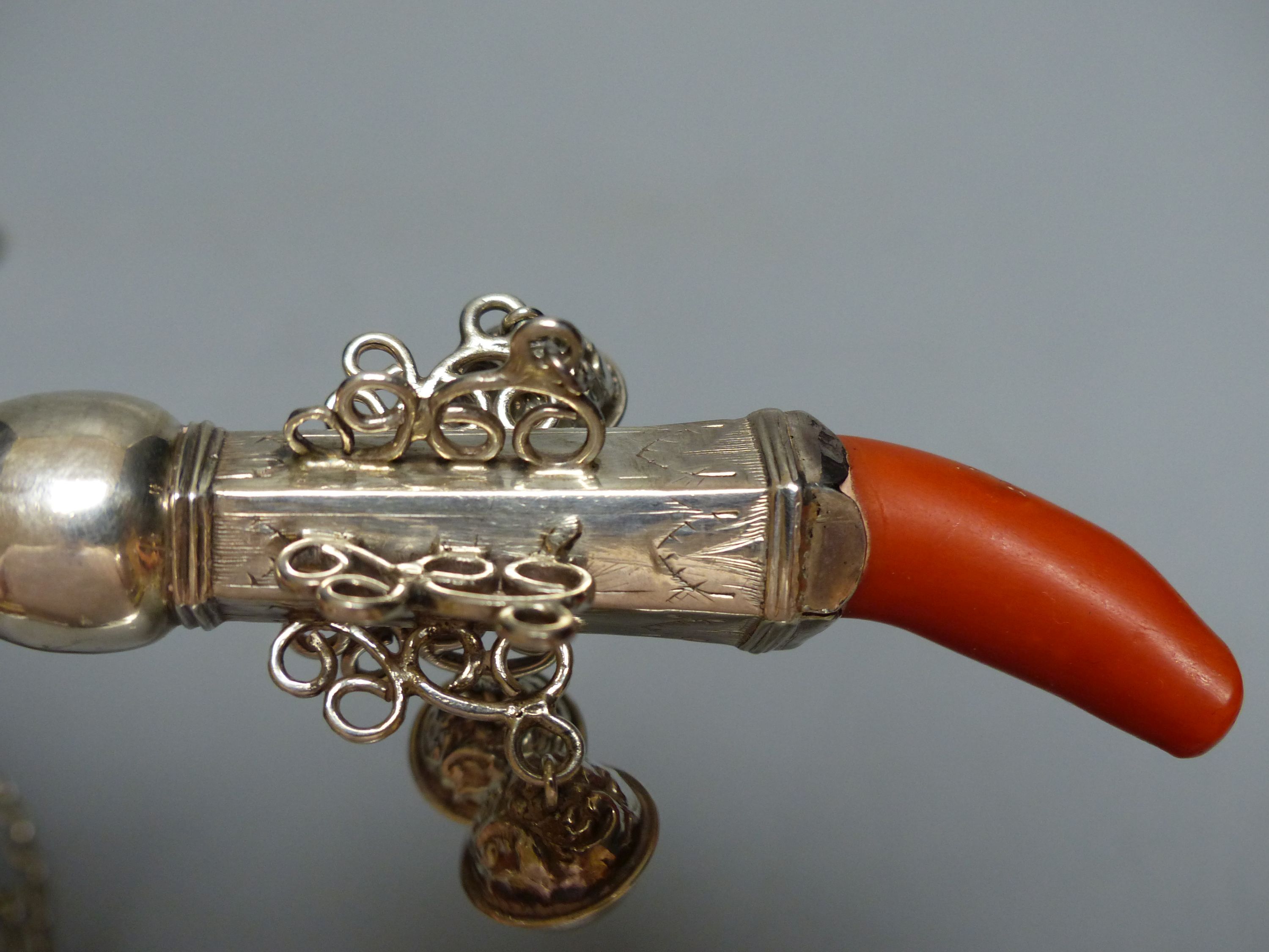 A 19th century? white metal child's rattle with coral teether and seven bells (2 detached) unmarked, 13cm,